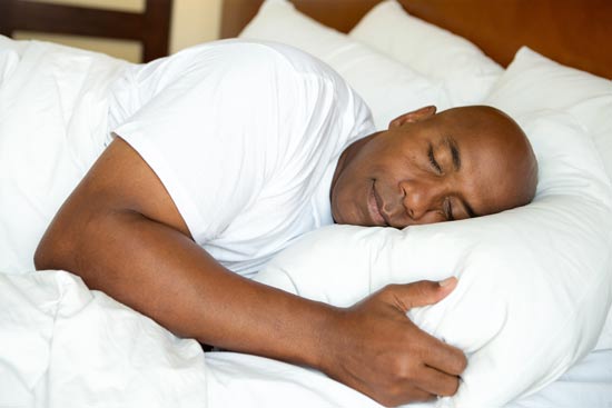 African american man sleeping on his side facing the camera